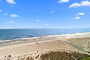 A beach with a sandy shore, a clear sky, and a calm sea. - Beachside Bliss: Oceanfront Suite w/ Breakfast (Myrtle Beach)