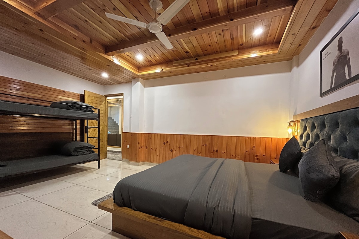 A bedroom with a large bed, a wooden ceiling, and a ceiling fan.
