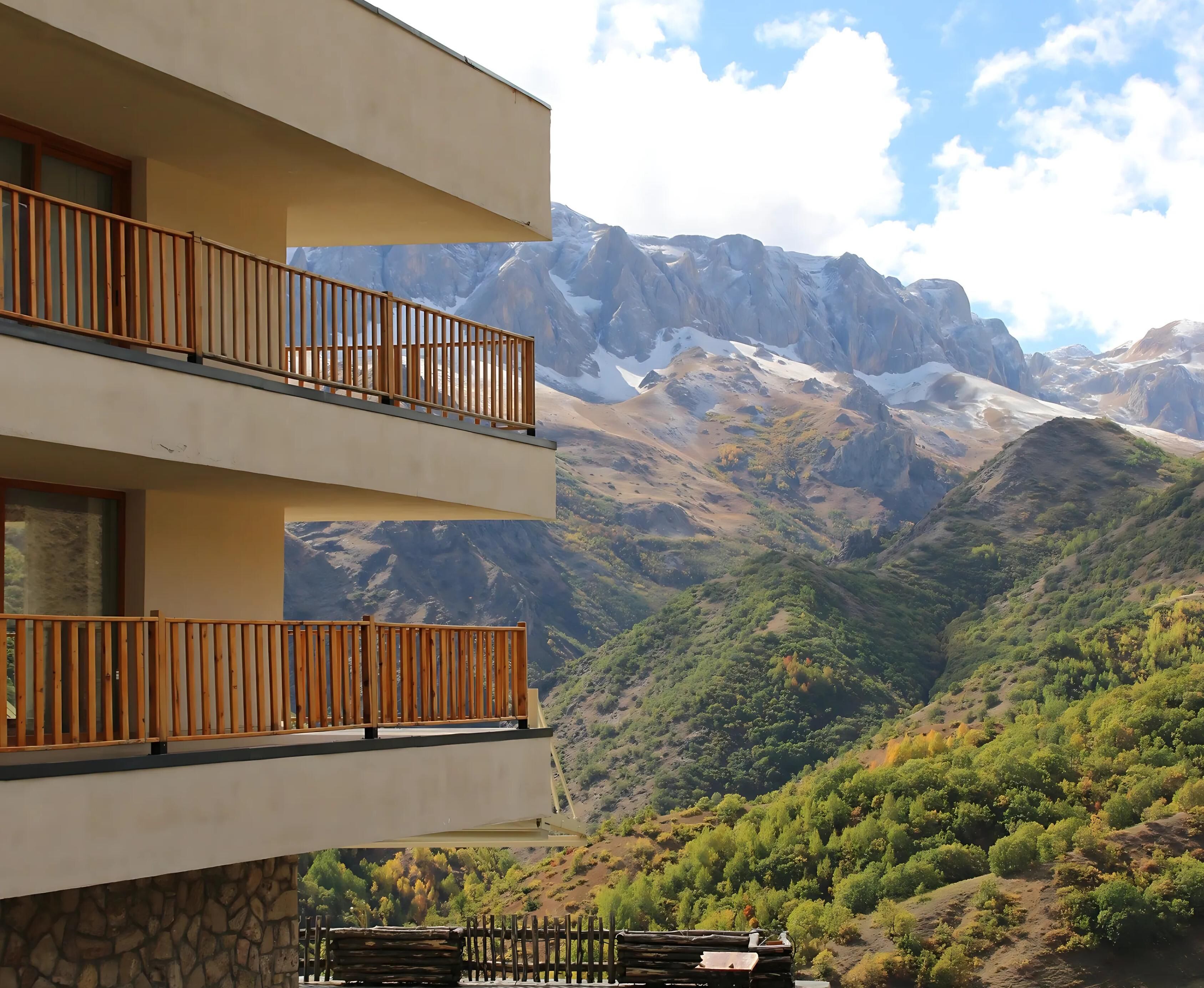 A hotel with a balcony overlooking a mountainous landscape.