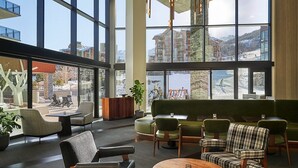 A spacious lobby with large windows offering views of a snowy landscape and buildings.