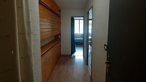 A narrow hallway with wooden paneling on one side and a door on the other. - Studio 2/3 pers 20m from gondola, equipped kitchen, south balcony, pets allowed (Valfréjus)