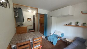 A compact living space with a dining area, a kitchenette, a sofa, and a small table. - Studio 2/3 pers 20m from gondola, equipped kitchen, south balcony, pets allowed (Valfréjus)
