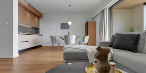 Un salon moderne comprenant un canapé, une table basse et un coin repas avec des chaises et une table.