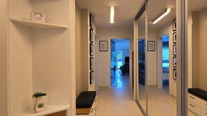 A hallway with a bench, a plant, and a Chanel bag on a shelf. - 3-room apartment (approx. 141 m²) for 6 people, with large roof terrace, in a quiet location (Graal-Müritz)