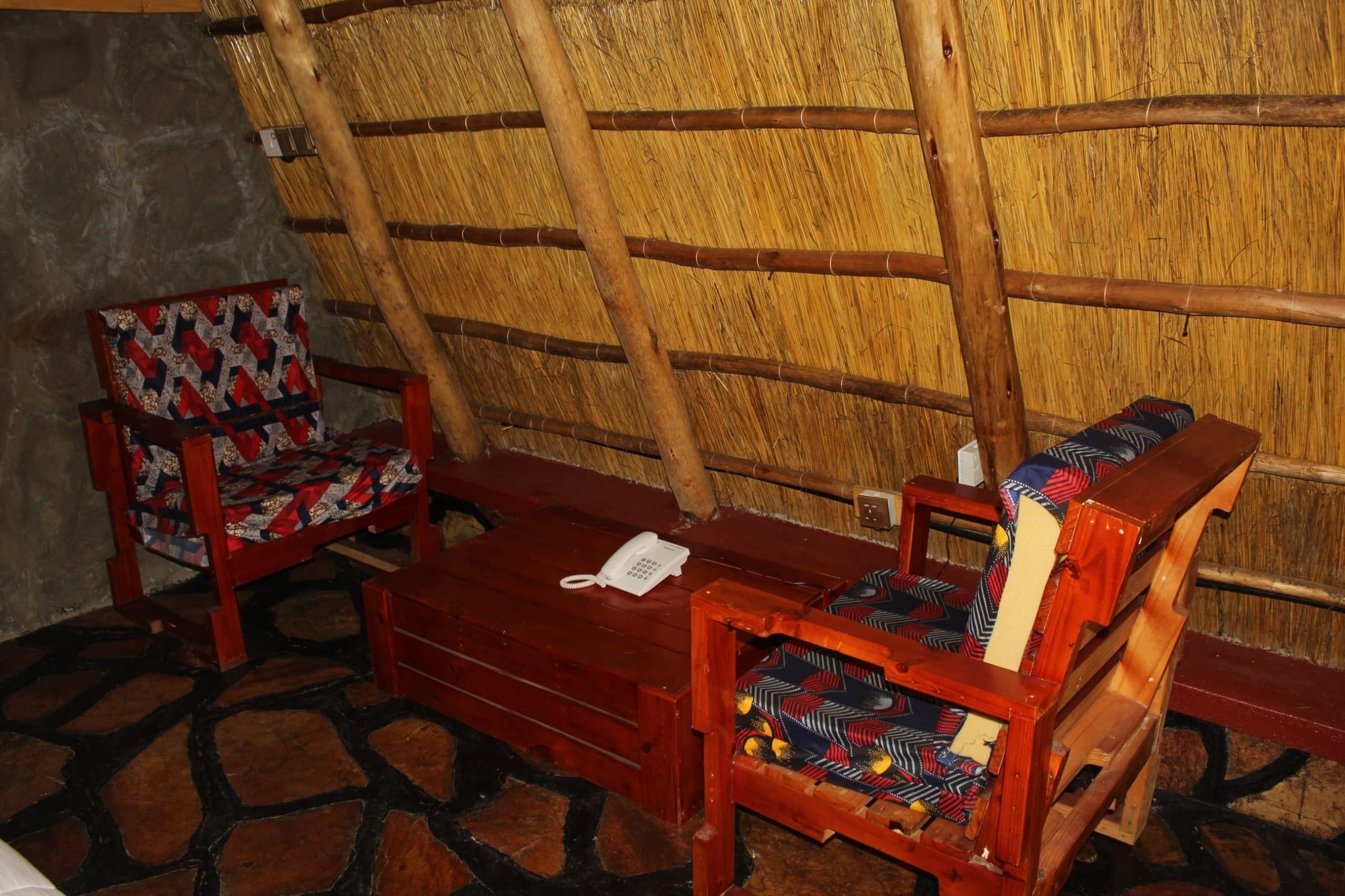 Una habitación tradicional con techo de paja, muebles de madera y suelo de piedra.