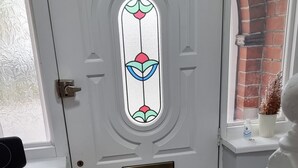 A white door with a stained glass window, a brass mail slot, and a black doormat. - Victoria Avenue Charm - Manchester Hideaway (Manchester)