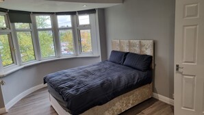 A bedroom with a bed, a window, and a door. - Victoria Avenue Charm - Manchester Hideaway (Manchester)