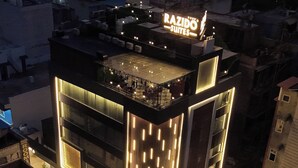 Un bâtiment moderne avec une enseigne lumineuse indiquant « RAZIDO SUITES ».