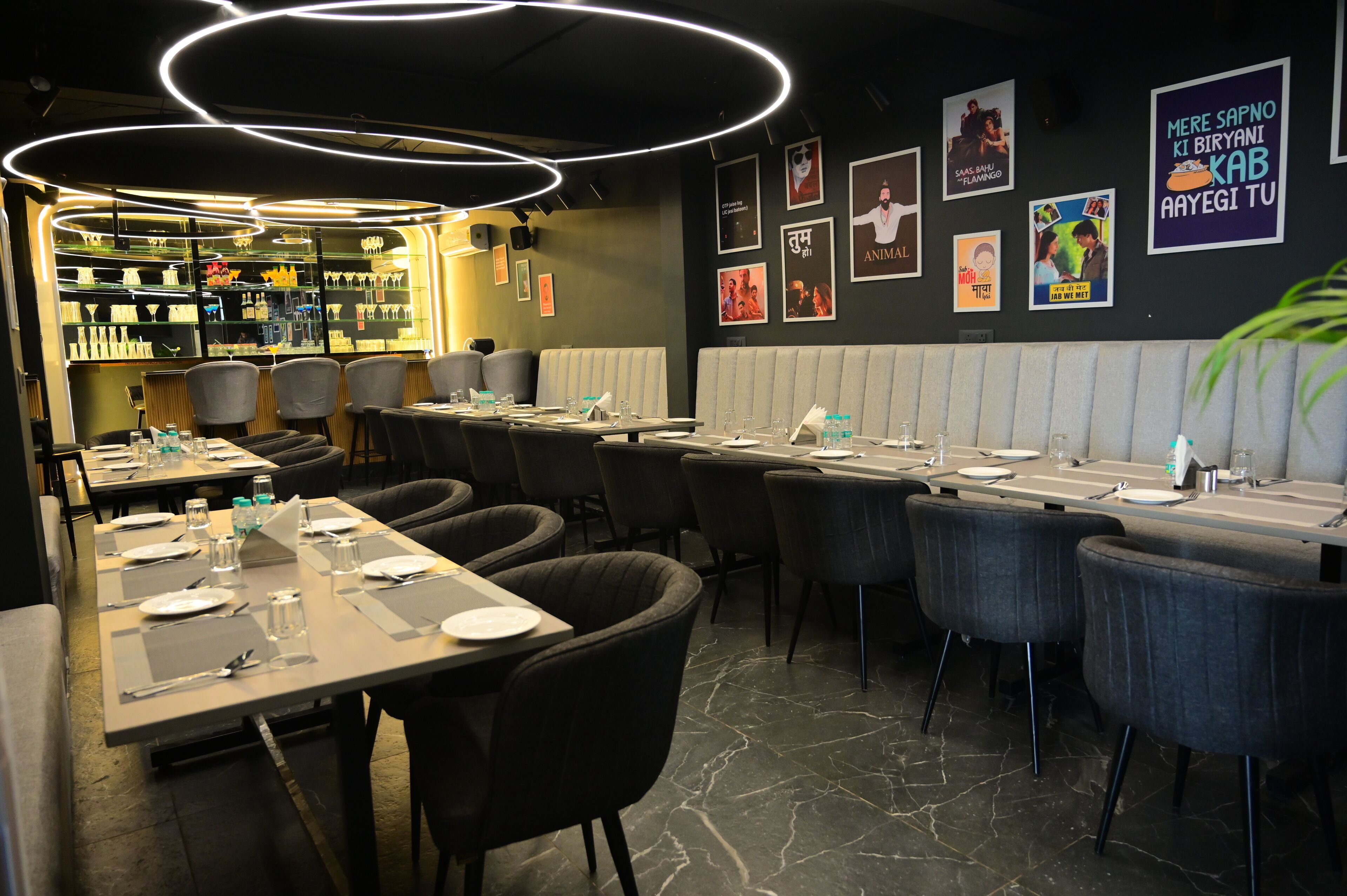 Un restaurante con varias mesas, sillas y una zona de bar.