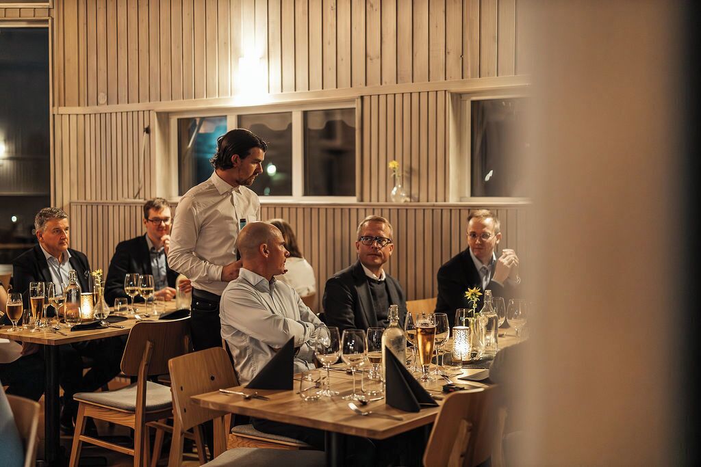 A restaurant with wooden paneling and large windows.