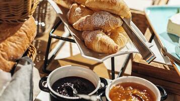 Un buffet de petit-déjeuner proposant des viennoiseries, des confitures et une pancarte indiquant : « Petit-déjeuner à la sauce assistancialiste ».