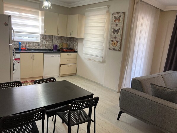 A compact living space with a dining area, kitchenette, and a sofa. - Dalaman Pansiyon (Dalaman)