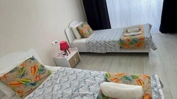 Une chambre d’hôtel avec deux lits, une table de chevet, une lampe et un appareil de climatisation.