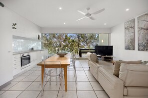 Una cocina moderna con comedor, sofá y televisor.