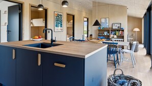 A modern kitchen with a central island, built-in cabinets, and pendant lighting. - "Aatos" - 250m from the sea by Interhome (Knebel)