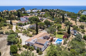 Vue aérienne d’un quartier résidentiel avec des maisons, des arbres et une piscine.