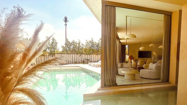 A modern living room with a pool, large windows, and a view of the outdoors. - Palais Harmonia (Marrakech)