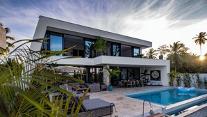 A modern two-story house with a swimming pool, outdoor seating, and tropical plants. - Villa Manglar Luxury Oceanfront (Las Terrenas)