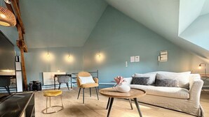 Una sala de estar moderna con techo alto, un sofá, una mesa de centro y una silla.