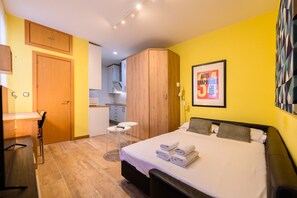 Ein Hotelzimmer mit einem Bett, einem Schreibtisch, einem Sessel, einem kleinen Tisch und einem Kleiderschrank.