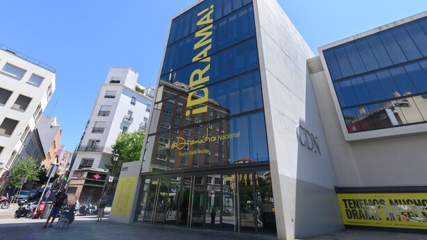 Un edificio moderno con fachada de vidrio y un letrero que dice "DRAMA Centro Teatros Nacional".