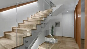Un escalier moderne avec des rampes en verre et des marches en bois.