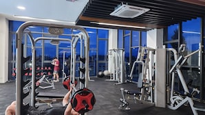 A gym with weightlifting equipment, a bench press, and a variety of machines.