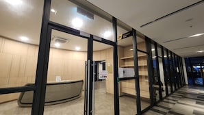 A reception area with a reception desk, a notice board, and a sign indicating a gym room.