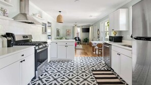 A modern kitchen with white cabinetry, a patterned floor, and a central island.