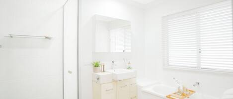Un baño moderno con ducha, lavamanos y bañera.