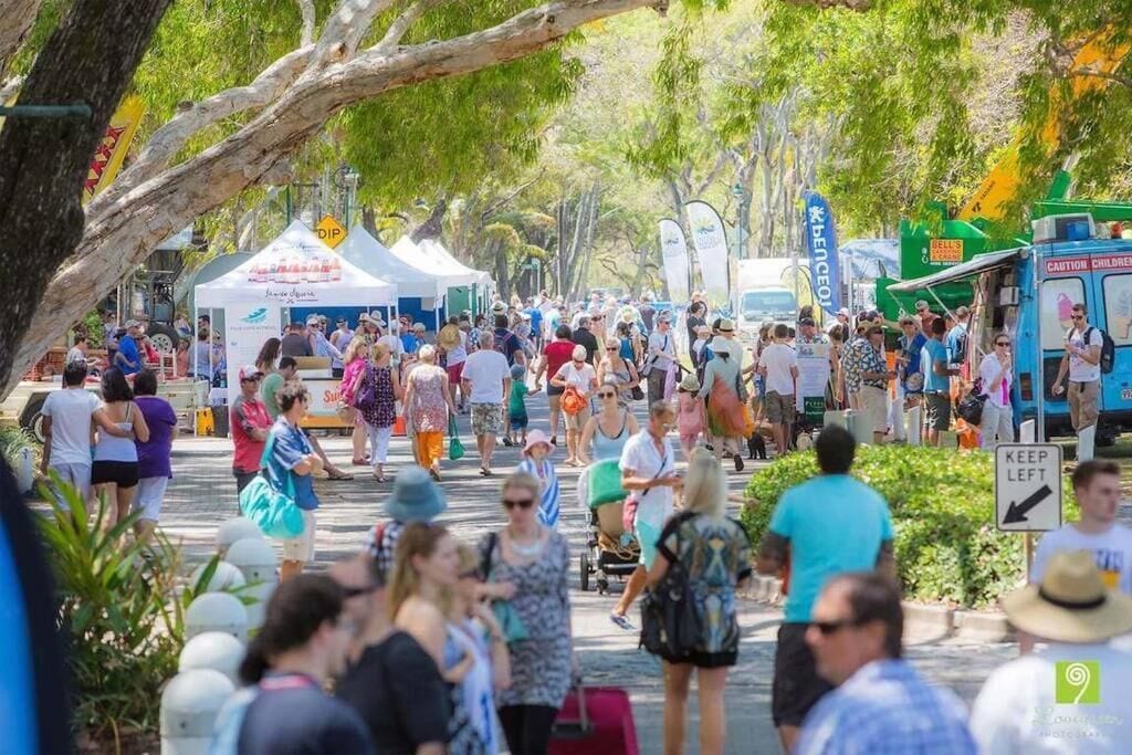 A crowded outdoor event with people walking and vendors.