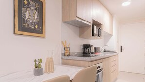 A modern kitchen with wooden cabinets, a microwave, and a coffee maker.