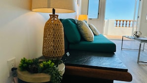 A modern living room with a sofa, a lamp, and a view of the outdoors. - Hamilton Cove Villa 9 58 With Zero Steps (Avalon)
