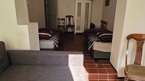 A room with two beds, a sofa, a chair, and a wardrobe. - House Rumpen 10 single beds 7 bedrooms with hot and cold water Brunssum  (Brunssum)