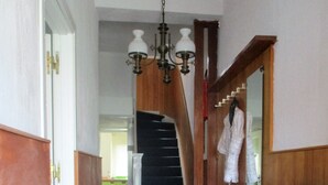 A hallway with a checkered floor, a wooden door, a radiator, and a staircase. - House Rumpen 10 single beds 7 bedrooms with hot and cold water Brunssum  (Brunssum)