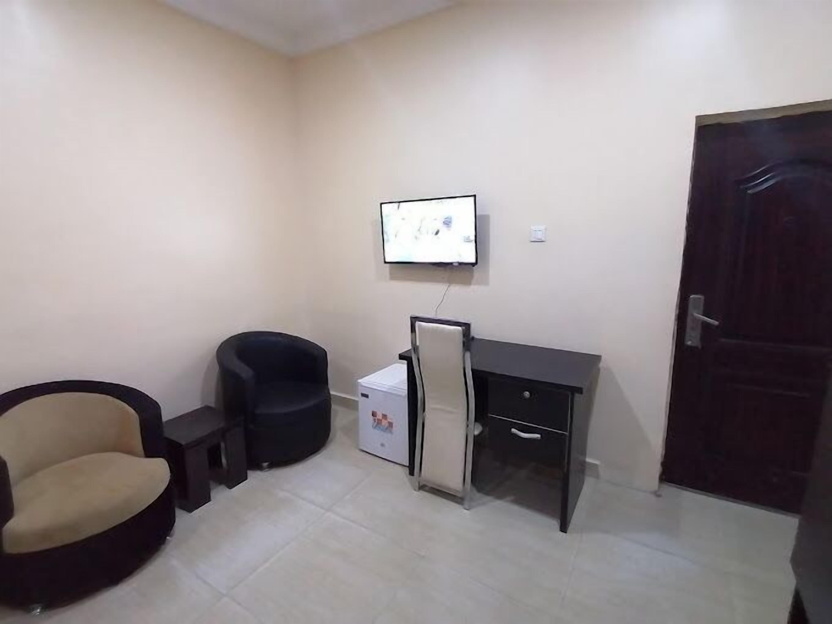 A small office space with a desk, chair, and a refrigerator.