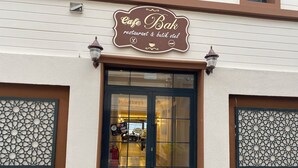 A building entrance with a sign reading "Cafe Bak restaurant & butik otel". - Bak cafe& pansiyon (Ayvalik)