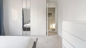 A bedroom with a bed, a wardrobe, and a door leading to another room. - Spacious 1 bed Apartment With Parking & Balcony! (Bromley)