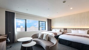 Habitación de hotel con una cama grande, un sofá, un escritorio y vistas de la ciudad.