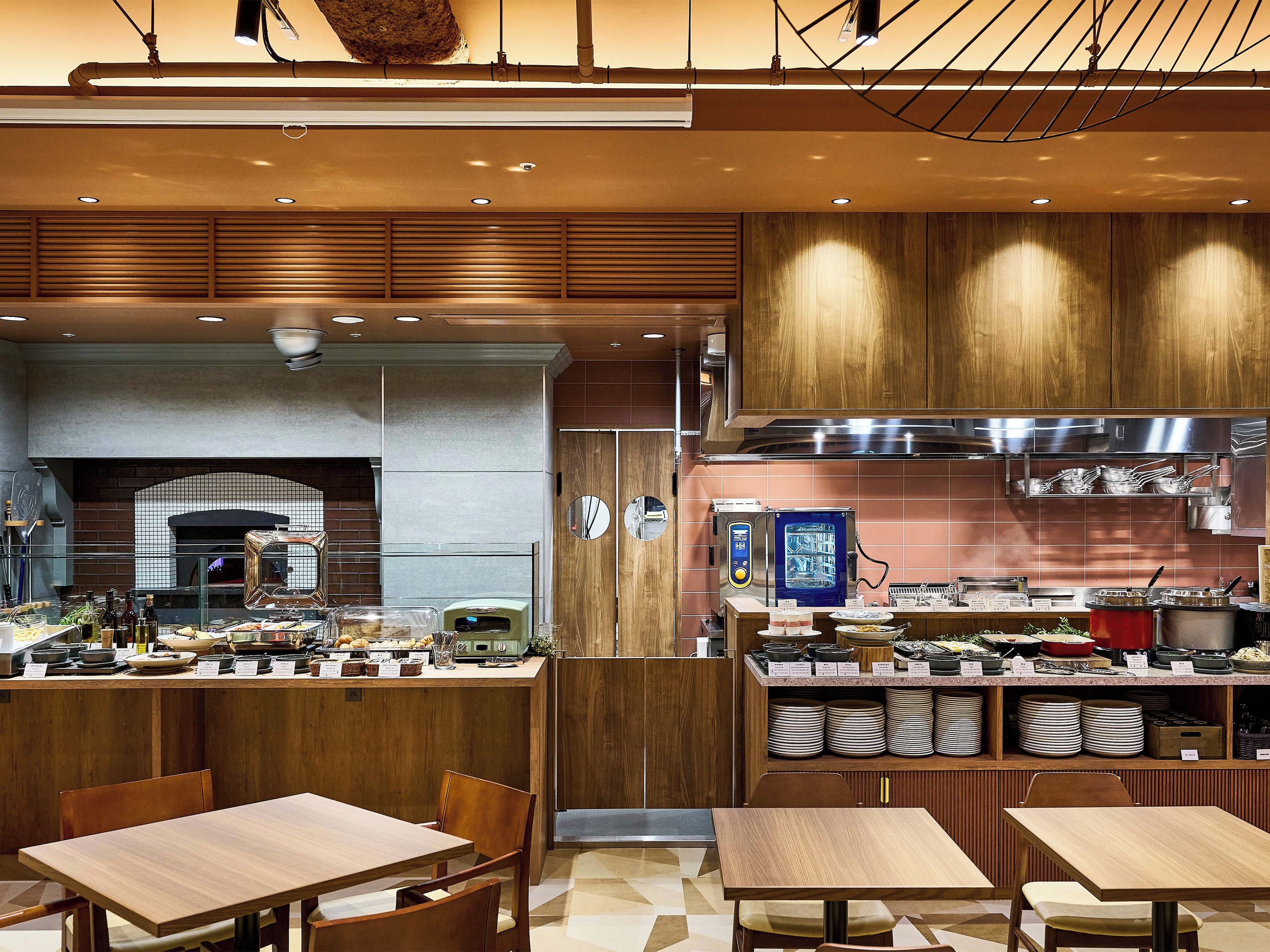 A modern kitchen with wooden cabinets, a built-in oven, and a stainless steel range hood.