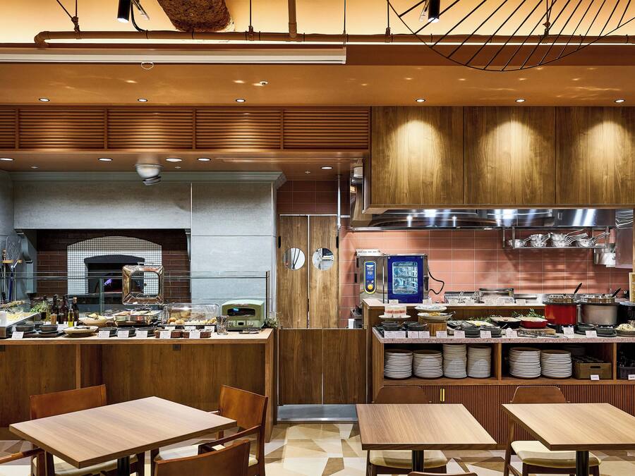 A modern kitchen with wooden cabinets, a built-in oven, and a stainless steel range hood.