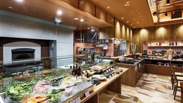 Espaço de buffet com diversas opções de comida e forno para pizza embutido.