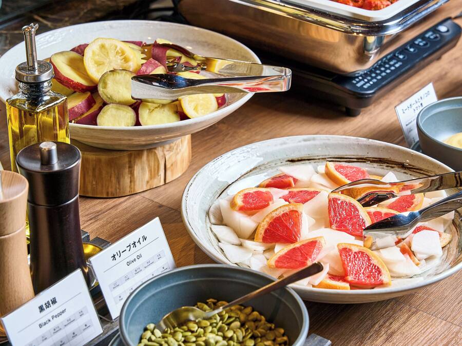 Ein Tisch mit verschiedenen Speisen, darunter Obstscheiben und eine Schüssel mit Saaten.