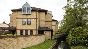 A multi-story brick building with a flat roof and a small attached structure. - Riverside Hotel (Cirencester)