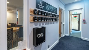 A hotel reception area with a sign for Riverside Hotel, a row of keycard locks, and a security keypad. - Riverside Hotel (Cirencester)