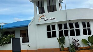 Un hotel chiamato "Sun Suites" con un'imponente torre e una facciata curva.