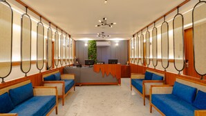 A reception area with a reception desk, two computer stations, and a reception sign. - Alokah Kashi (Varanasi)