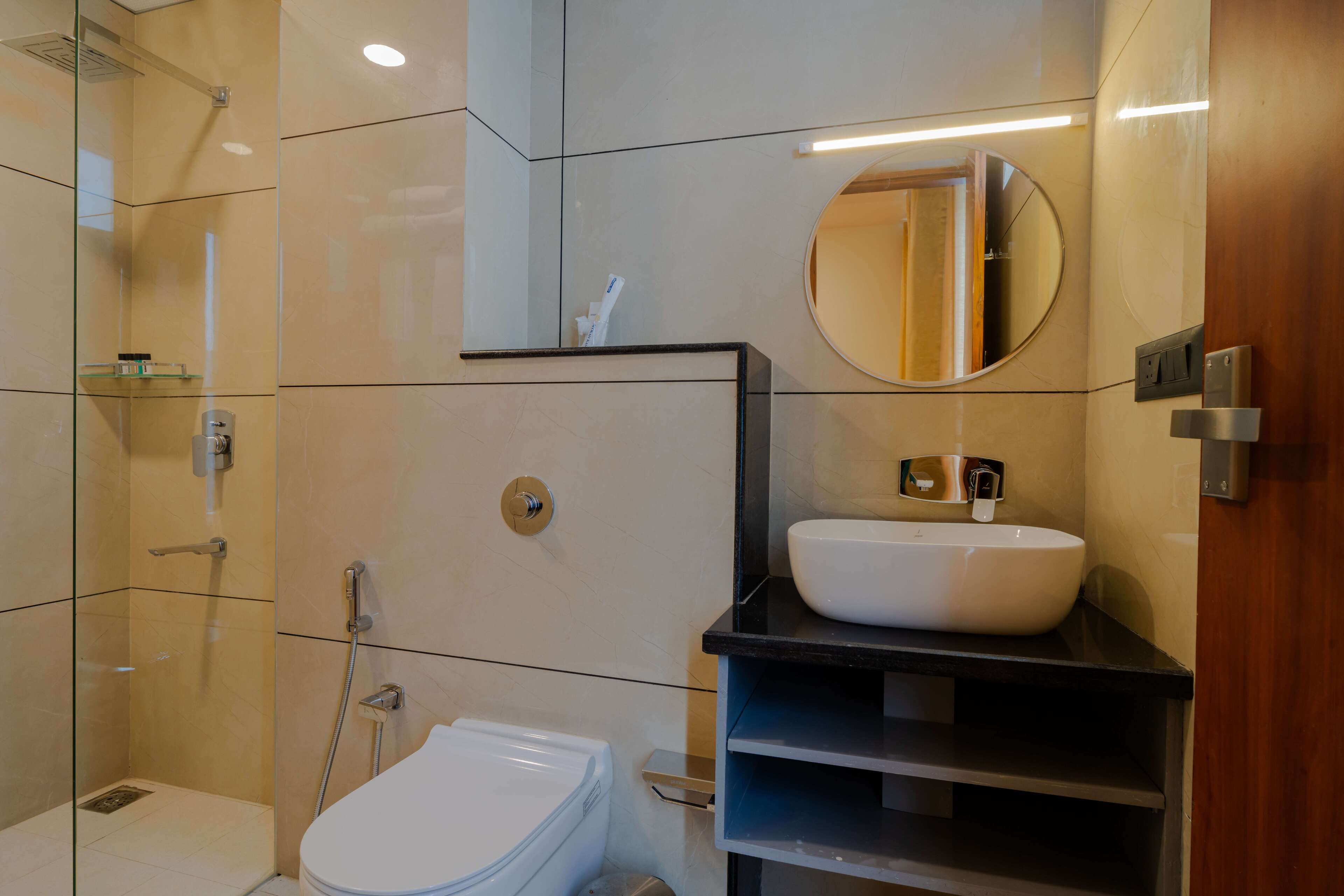 A modern bathroom with a glass-enclosed shower, a white toilet, and a black vanity with a sink.