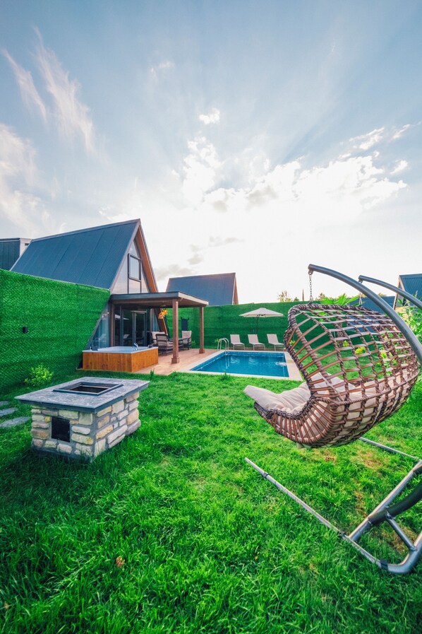 A modern house with a swimming pool, a hanging chair, and a stone fire pit. - Majesty Sapanca (Sapanca)