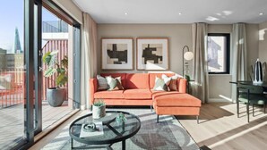 A modern living room with a sofa, a coffee table, and two framed abstract paintings.